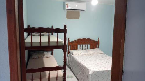 ein Schlafzimmer mit zwei Betten und einem Etagenbett in der Unterkunft Casa Porto in Porto Seguro