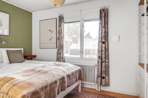 Schlafzimmer mit einem Bett und einem Fenster in der Unterkunft Retro Retreat with Modern Comforts in Stockholm