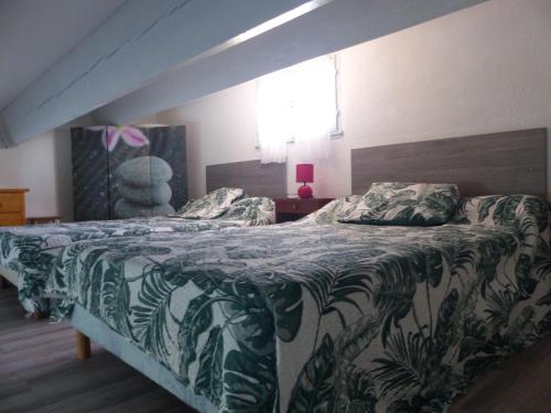 ein Schlafzimmer mit einem großen Bett mit einer grünen Bettdecke in der Unterkunft St Cyprien Maison de vacances climatisée avec jardin in Saint-Cyprien