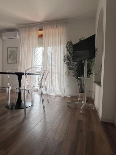 een woonkamer met een tafel en stoelen en een televisie bij Suite Monolocale Roma Eur in Rome
