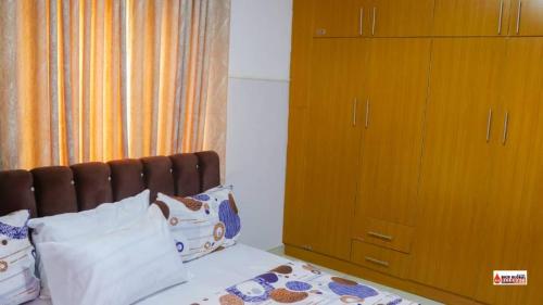 1 dormitorio con 1 cama y armario de madera en Richard Magodo Apartment, en Lagos