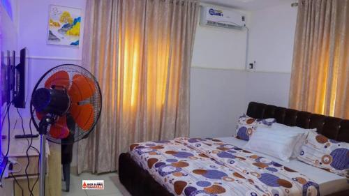 1 dormitorio con 1 cama y ventilador en Richard Magodo Apartment, en Lagos