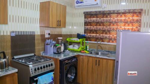 una cucina con piano cottura e lavatrice di Richard Magodo Apartment a Lagos