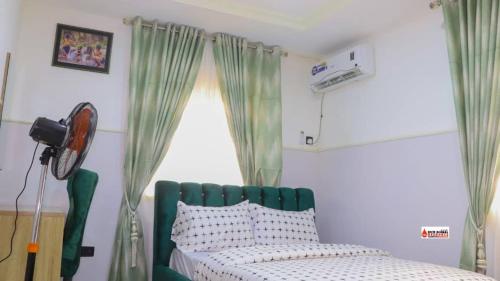 Un dormitorio con una cama verde y una ventana en Richard Magodo Apartment, en Lagos
