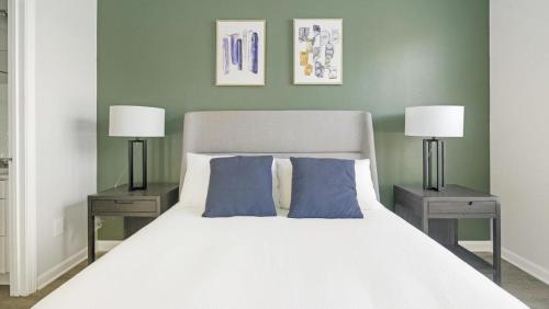 - une chambre avec un lit blanc et 2 lampes dans l'établissement Landing Modern Apartment with Amazing Amenities (ID9752X95), à Durham