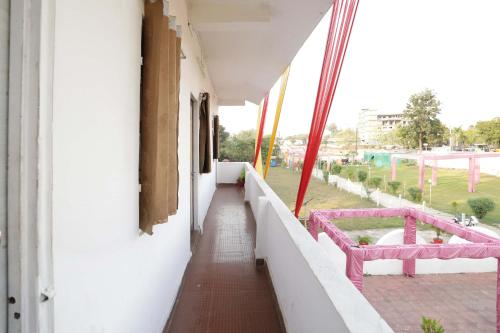 a corridor of a building with a pink bench at OYO Hotel Shahnai Garden in Bhopal