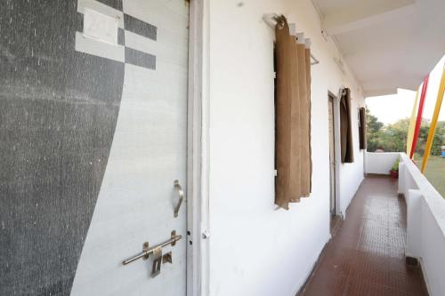 a hallway of a building with a door and a corridor at OYO Hotel Shahnai Garden in Bhopal