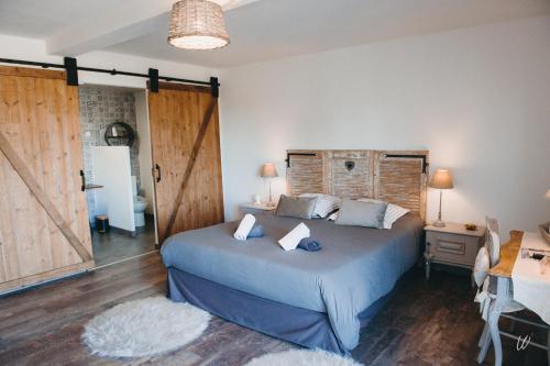 a bedroom with a large bed with a wooden headboard at Au charme d'antan in Féron