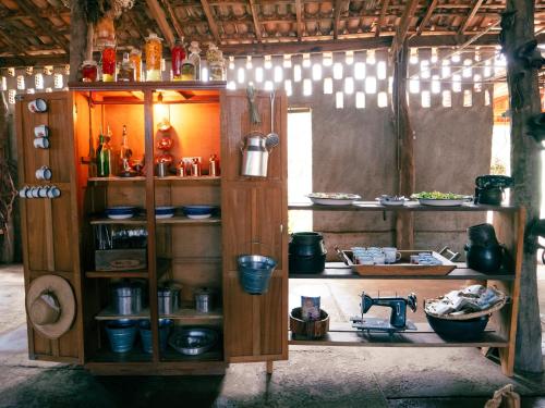 a kitchen with a shelf with pots and pans at Pousada Pantanal Experiência in Miranda