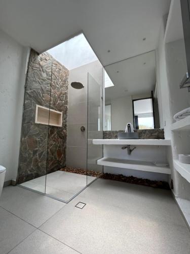a bathroom with a shower and a sink and a mirror at Casa Alcatraz in Puerto Colombia