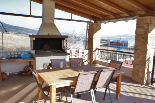 una mesa y sillas en un balcón con chimenea en Hillside View Villa, en Thermi