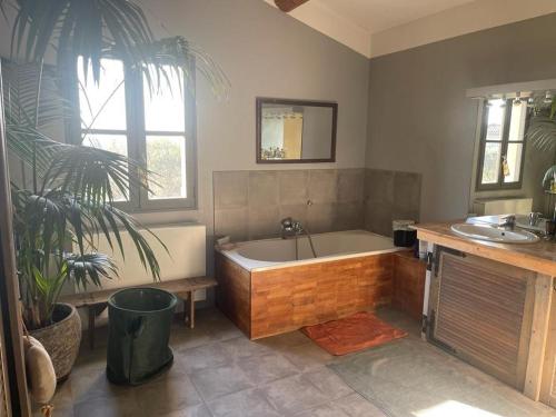 a bathroom with a bath tub and a sink at bastide Uzes à pied Piscine vue imprenable Havre de paix in Uzès
