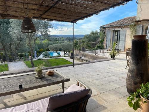 d'une terrasse avec une table et une vue sur une maison. dans l'établissement bastide Uzes à pied Piscine vue imprenable Havre de paix, à Uzès