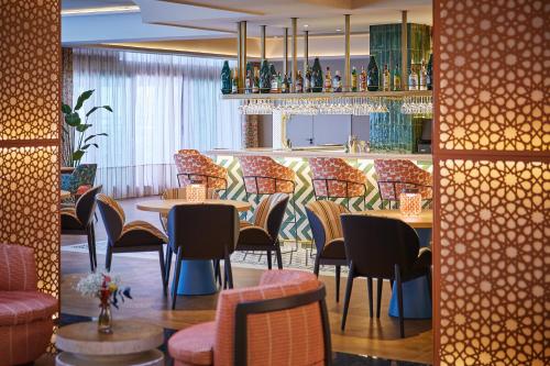 a restaurant with tables and chairs and a bar at Hesperia Sevilla in Seville
