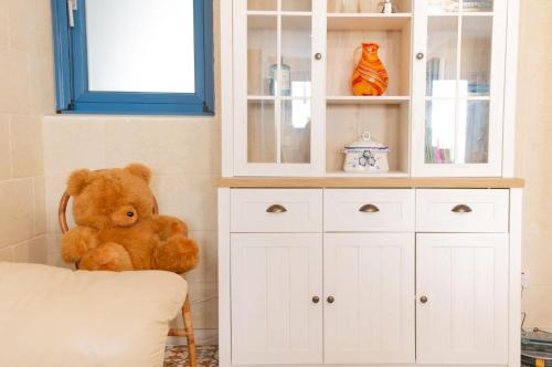 a teddy bear sitting on a chair in a room at A remarkable Eco Home in Gozo in Nadur