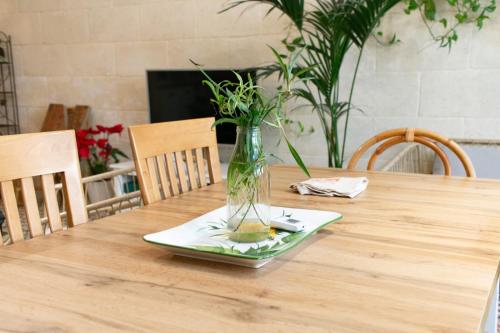 a vase sitting on a plate on a table at A remarkable Eco Home in Gozo in Nadur