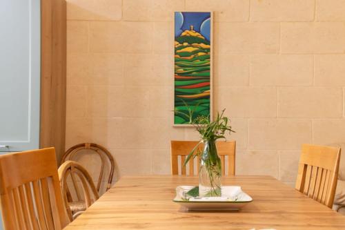 a wooden table with a vase on top of it at A remarkable Eco Home in Gozo in Nadur
