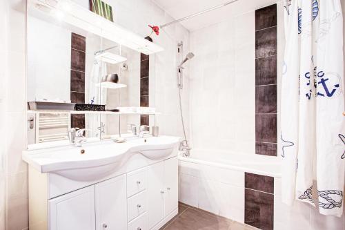 a white bathroom with a sink and a shower at VERT PARADIS - Vue apaisante sur GOLF, Pins Parasols, 2è étage - 80 m2 dont Terrasse avec Pergola, 2 chambres, 3ét iles, 3 CLIM, WIFI - Piscine, Parking et Park à vélos, Ascenseur - en Option Linge, Ménage - Pistes cyclables, Mer à proximité in Saint-Cyprien