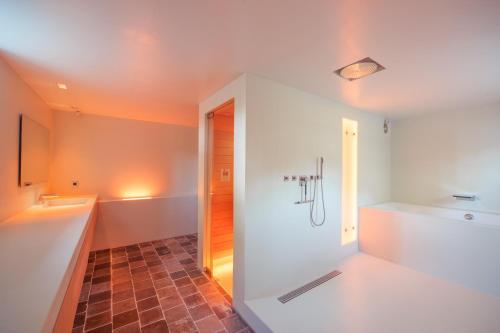 a bathroom with a shower and a tub and a sink at Logies Groot Okhorst in Wichmond