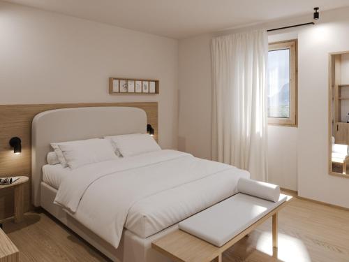 Un dormitorio blanco con una gran cama blanca y una ventana en Hotel Al Maso, en Riva del Garda