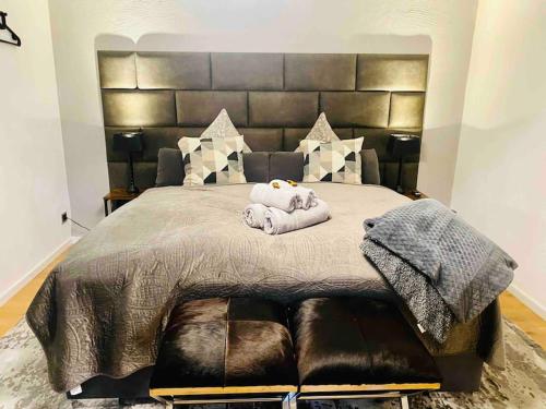 ein Schlafzimmer mit einem großen Bett mit einem großen Kopfteil in der Unterkunft 80qm Luxus Apartment mit großer Terrasse in Saarbrücken