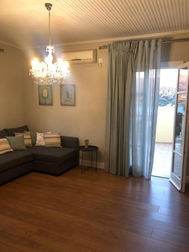 ein Wohnzimmer mit einem Sofa und einem Kronleuchter in der Unterkunft Barbara΄s Apartments in Argostoli
