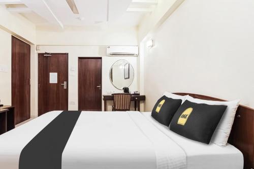 a bedroom with a bed with black and white pillows at Jupiter Gold Delhi Airport in New Delhi
