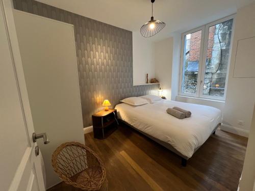 um quarto com uma grande cama branca e uma janela em Le Saint Nicolas~Hyper centre em Blois
