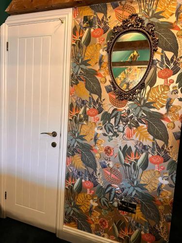 a mirror on a wall with a floral wallpaper at Kip 23 JJs Emsworth in Emsworth