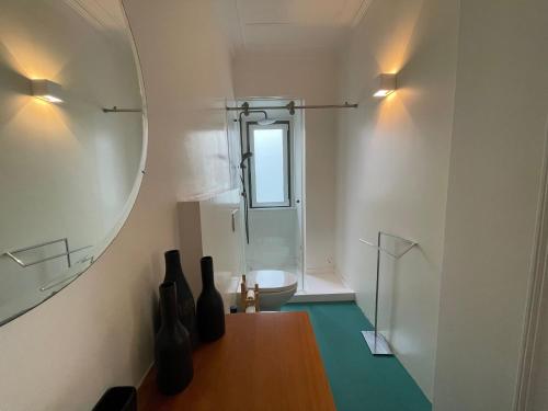 uma casa de banho com um espelho, uma mesa e um lavatório. em Charming beach house em São Martinho do Porto