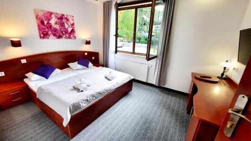 a bedroom with a bed with two teddy bears on it at Malachit Karpacz SPA Hotel in Karpacz