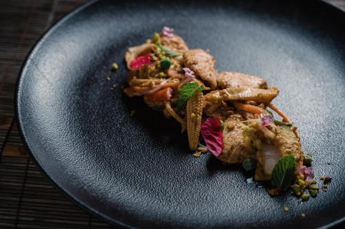 a black plate of food on a table at Lindos Imperial Resort & Spa in Kiotari