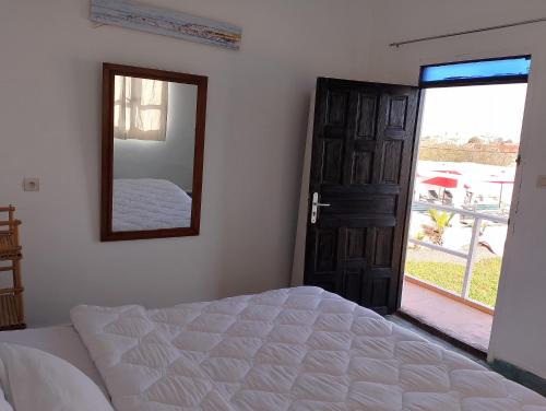 a bedroom with a bed and a mirror and a door at Riad & Restaurant Ocean Beach Douira in Agadir