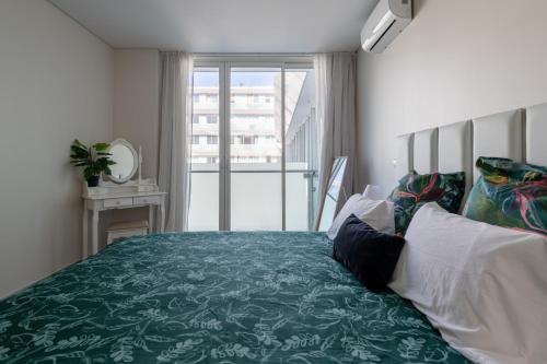 een slaapkamer met een groen bed en een raam bij Funchal Plaza in Funchal