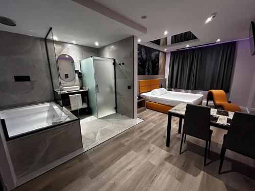 a bathroom with a shower and a sink and a tub at Zouk Hotel in Alcalá de Henares