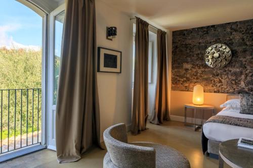a hotel room with a bed and a balcony at Donna Carmela Resort & Lodges in Riposto