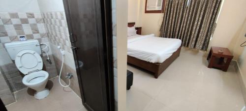 a bathroom with a toilet and a bed in a room at Goroomgo Annapurna Resort Puri Near Sea Beach - Comfortable Stay with Family in Puri