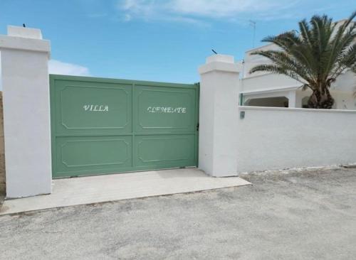 a green garage door in front of a house at Villa Clemente in Marina di Lizzano