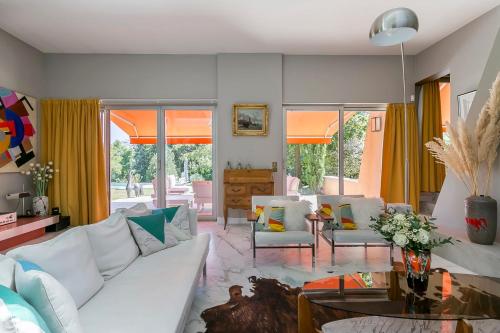 una sala de estar con muebles blancos y cortinas amarillas. en Villa - La champenoise - Hamac Suites en Saint-Didier-au-Mont-dʼOr