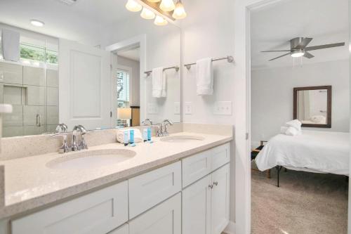 a bathroom with two sinks and a large mirror at Ride The Wave 5 min to Beach 7 min to Dtwn in Charleston