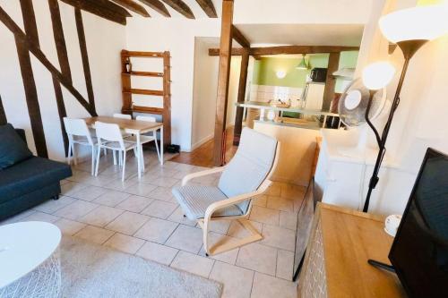 un salon avec une chaise et une table dans l'établissement FONTAINEBLEAU RUE GRANDE - Chez Alexis, à Fontainebleau