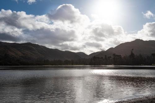a body of water with mountains in the background at The Ullswater Inn- The Inn Collection Group in Glenridding