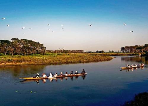 a group of people in a boat on a river at Horizon Homes - Sauraha Chitwan in Sauraha