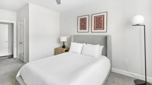 1 dormitorio blanco con 1 cama grande con almohadas blancas en Landing Modern Apartment with Amazing Amenities (ID9022X02), en Frisco