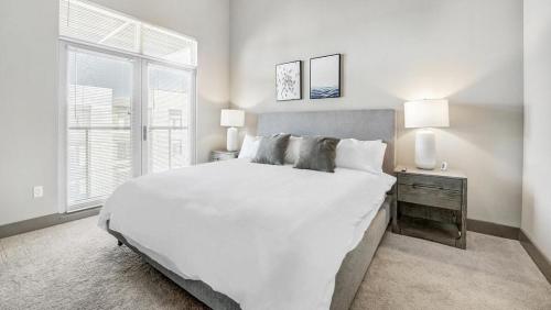 a white bedroom with a large bed and a window at Landing Modern Apartment with Amazing Amenities (ID1000X551) in Westlake