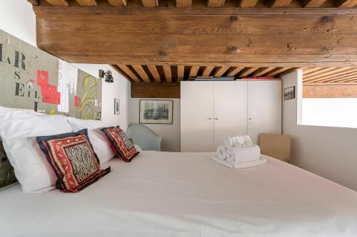 - une chambre avec un grand lit blanc et des oreillers dans l'établissement Hamac Suites- Le Jacquard Croix-Rousse - 2pers, à Lyon