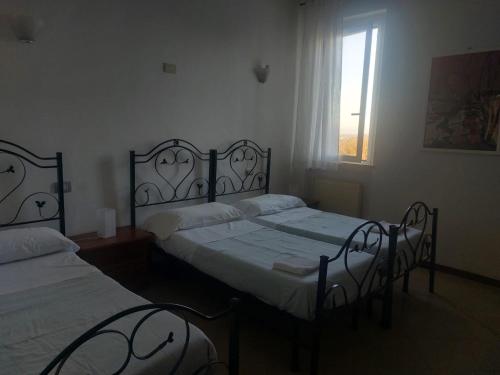 two twin beds in a room with a window at Il Portichetto in Rivergaro