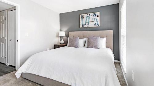 een slaapkamer met een wit bed met een witte sprei bij Landing Modern Apartment with Amazing Amenities (ID5679) in Canal Winchester