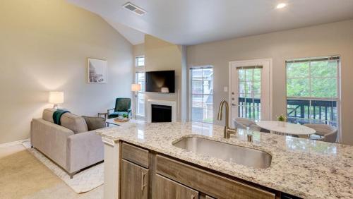 cocina con fregadero y sala de estar. en Landing Modern Apartment with Amazing Amenities (ID4600X56) en Irving