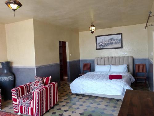 a bedroom with a white bed and two chairs at Riad & Restaurant Ocean Beach Douira in Agadir